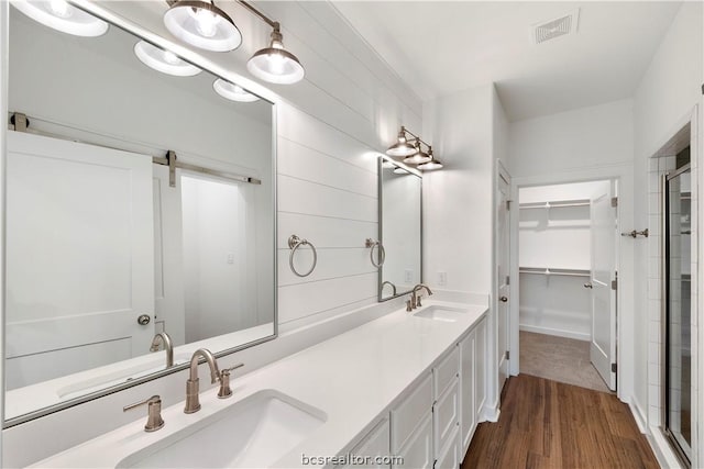 bathroom featuring vanity, an enclosed shower, and wood-type flooring