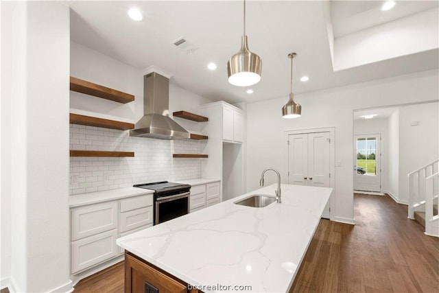 kitchen featuring white cabinetry, sink, ventilation hood, an island with sink, and stainless steel range with electric stovetop