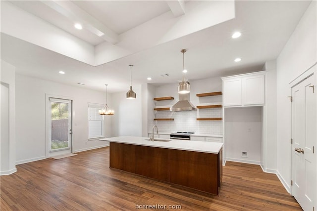 kitchen featuring white cabinets, dark hardwood / wood-style flooring, a kitchen island with sink, and hanging light fixtures