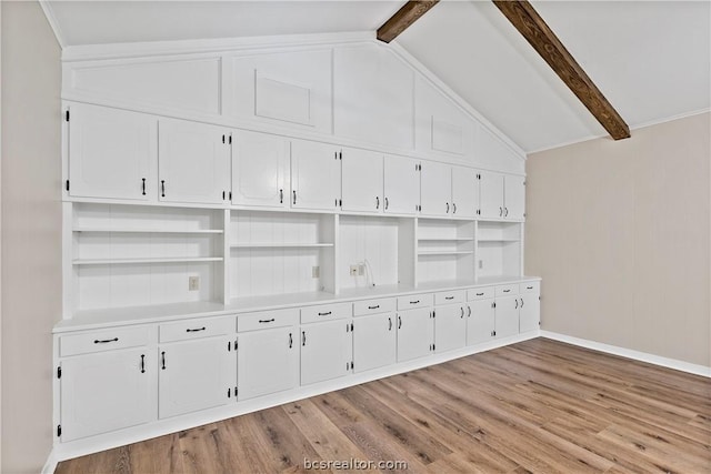 interior space with lofted ceiling with beams and light hardwood / wood-style flooring