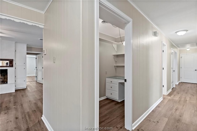 corridor with crown molding and light hardwood / wood-style flooring