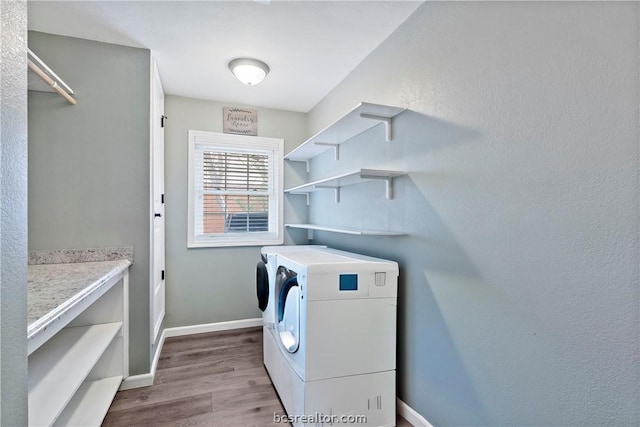 laundry room with light hardwood / wood-style flooring and washer and dryer