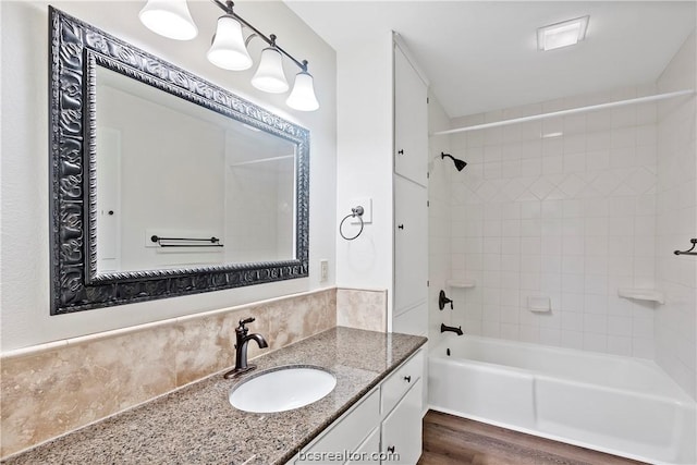 bathroom featuring vanity, tiled shower / bath combo, and hardwood / wood-style flooring