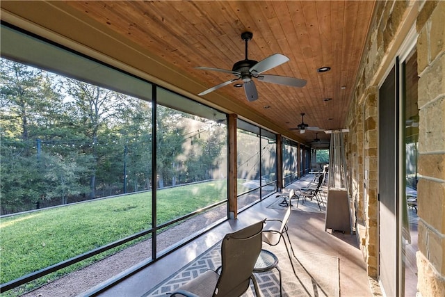 unfurnished sunroom with ceiling fan and wood ceiling