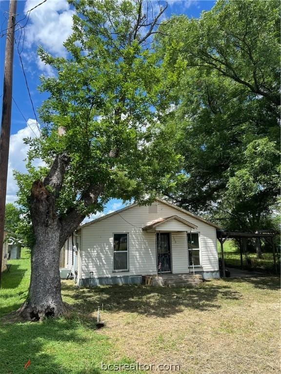 view of front of house with a front lawn and a carport