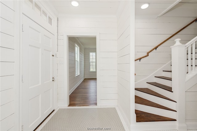 entryway featuring wood-type flooring and wooden walls