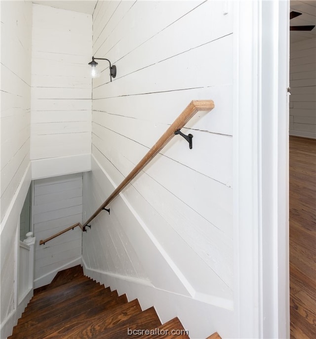 stairs featuring wooden walls and hardwood / wood-style flooring