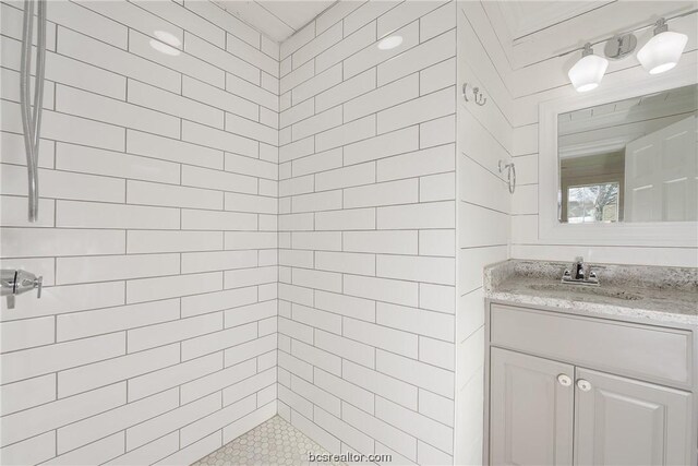 bathroom featuring a tile shower and vanity