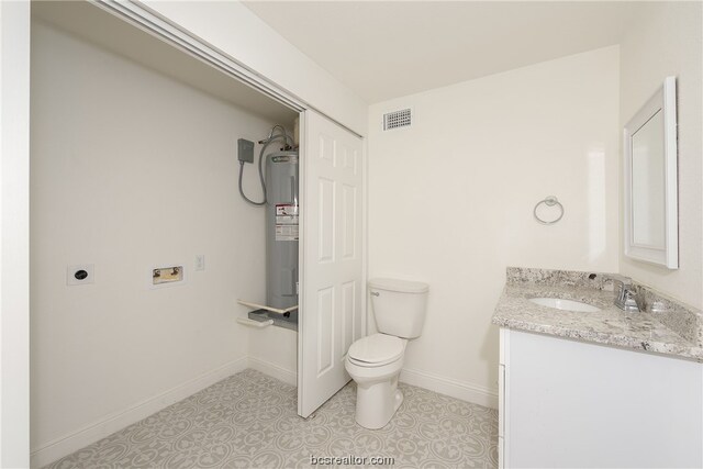 bathroom with electric water heater, vanity, and toilet