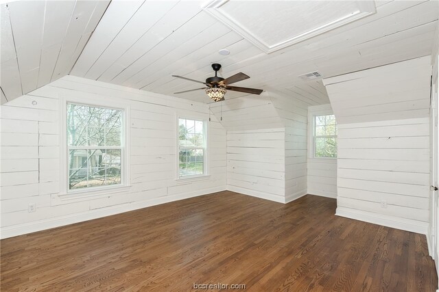 empty room featuring plenty of natural light, dark hardwood / wood-style flooring, lofted ceiling, and wooden ceiling