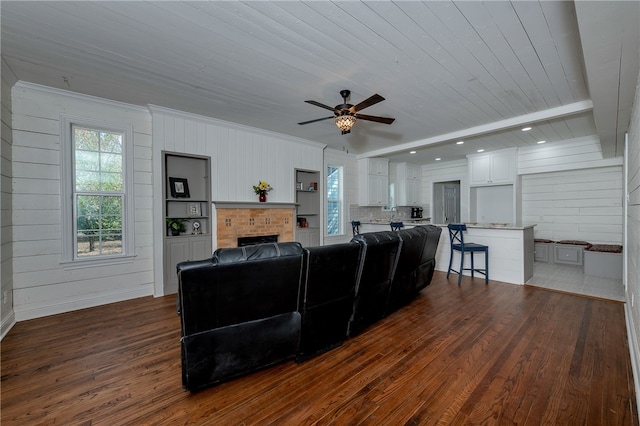 living room with ceiling fan, wooden ceiling, dark hardwood / wood-style floors, wooden walls, and a fireplace