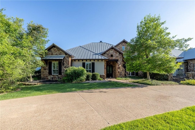 17288 Indian Lakes Dr, College Station, TX 77845 - view of front of house with stone siding, a standing seam roof, a metal roof, and a front yard