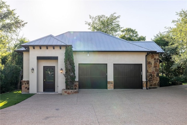17288 Indian Lakes Dr, College Station, TX 77845 - view of front of home featuring stone siding, an attached garage, concrete driveway, a standing seam roof, and stucco siding