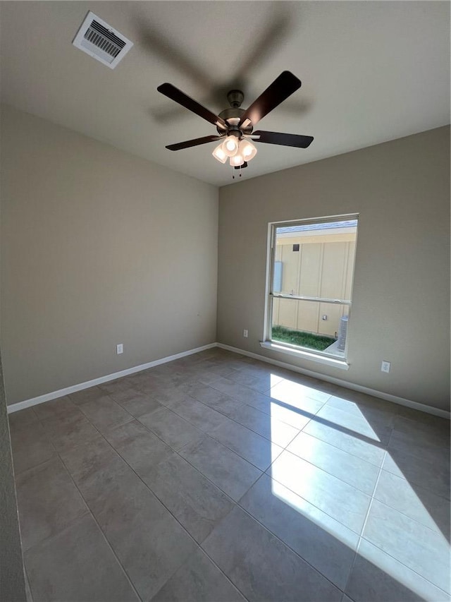 spare room with ceiling fan and light tile patterned floors