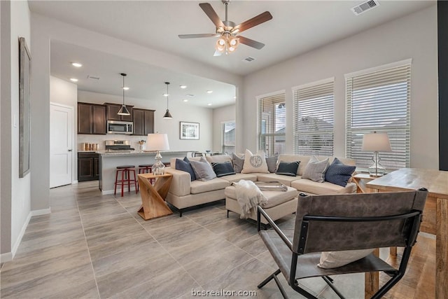 tiled living room with ceiling fan