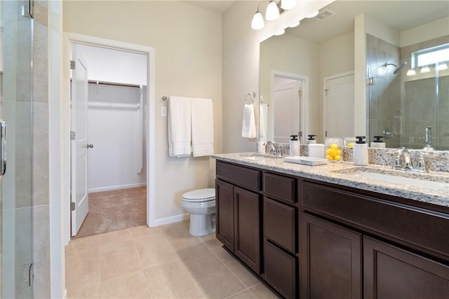 bathroom featuring tile patterned flooring, vanity, toilet, and walk in shower