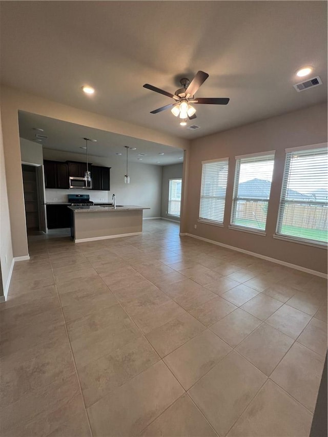 unfurnished living room with sink, ceiling fan, and light tile patterned flooring