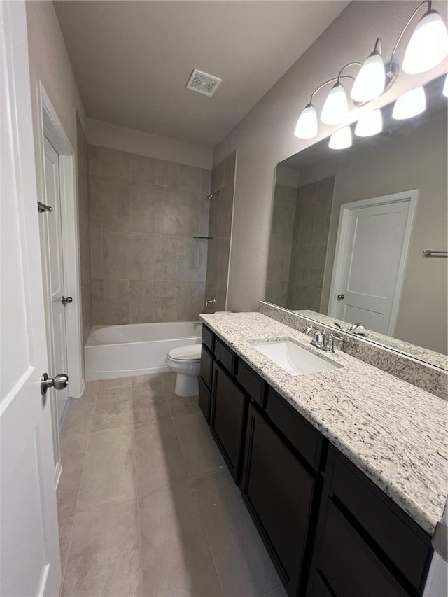 full bathroom with toilet, tile patterned flooring, vanity, and tiled shower / bath