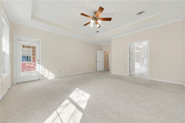 carpeted empty room featuring a tray ceiling, ceiling fan, and crown molding