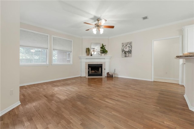 unfurnished living room featuring a fireplace, wood-type flooring, ceiling fan, and ornamental molding