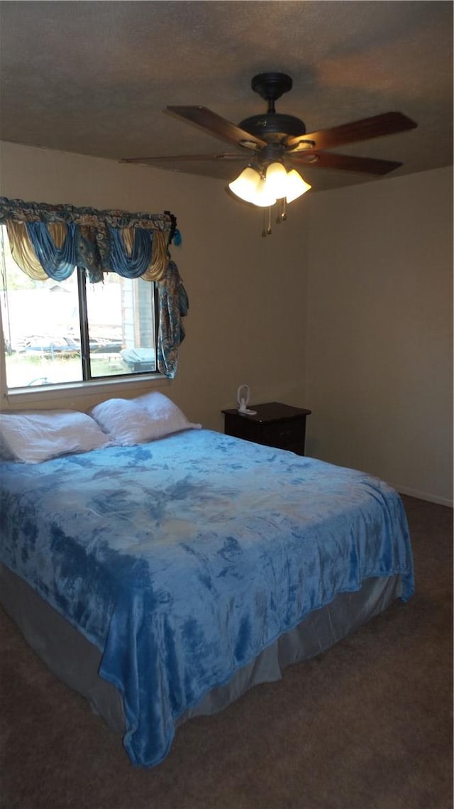 bedroom featuring dark colored carpet and ceiling fan