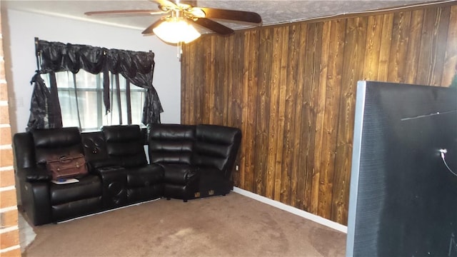 carpeted living room featuring wood walls and ceiling fan