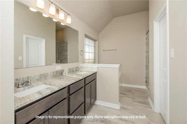 bathroom with hardwood / wood-style flooring, vanity, lofted ceiling, and a shower with door