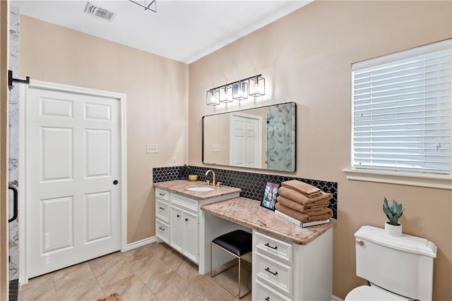 bathroom with tile patterned floors, vanity, toilet, and tasteful backsplash