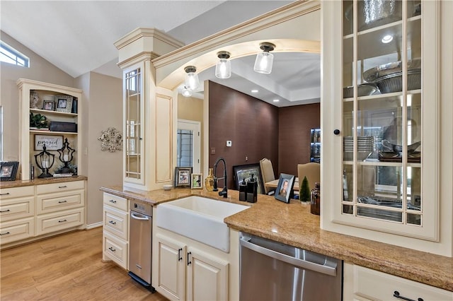 kitchen featuring sink, vaulted ceiling, stainless steel dishwasher, light hardwood / wood-style floors, and light stone counters