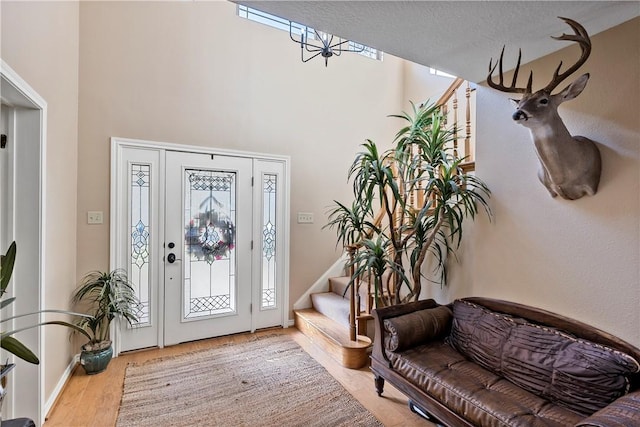 foyer entrance with a textured ceiling and light wood-type flooring