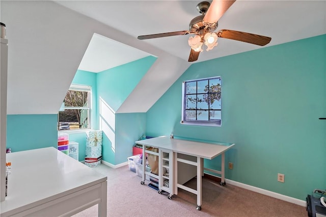 carpeted home office with ceiling fan and vaulted ceiling