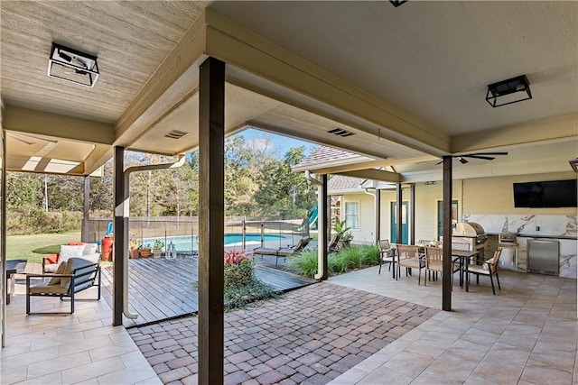 view of patio with ceiling fan, area for grilling, and a fenced in pool