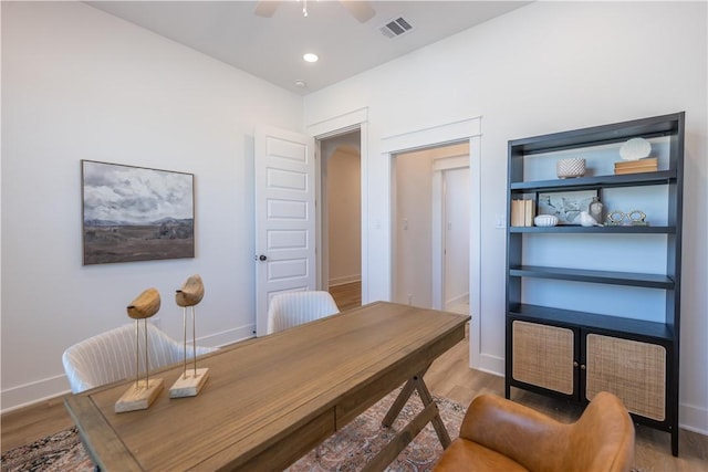 home office featuring visible vents, baseboards, a ceiling fan, and wood finished floors