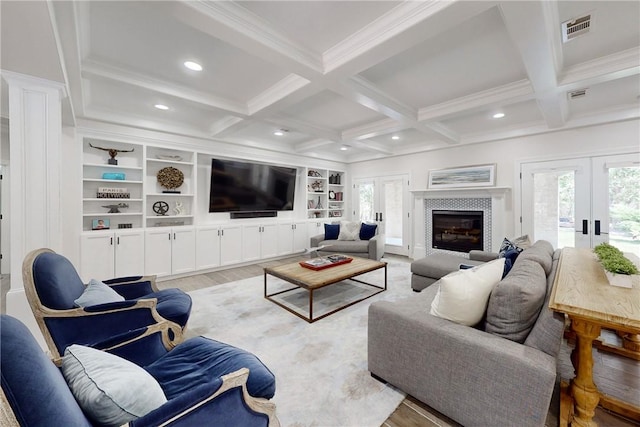 living room featuring french doors, beamed ceiling, light hardwood / wood-style floors, and built in features