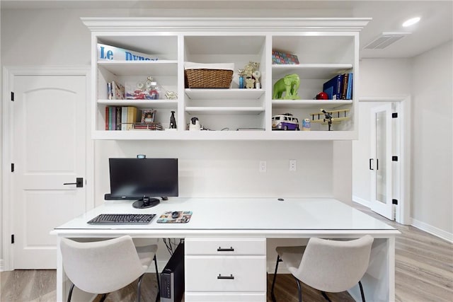 office with built in desk and light hardwood / wood-style floors