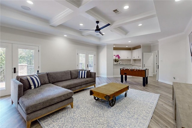 living room with coffered ceiling, ornamental molding, light hardwood / wood-style flooring, and french doors