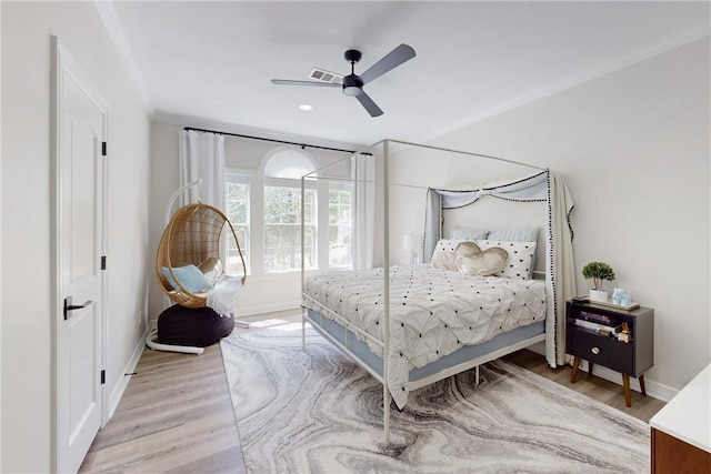 bedroom featuring light hardwood / wood-style floors, ceiling fan, and ornamental molding