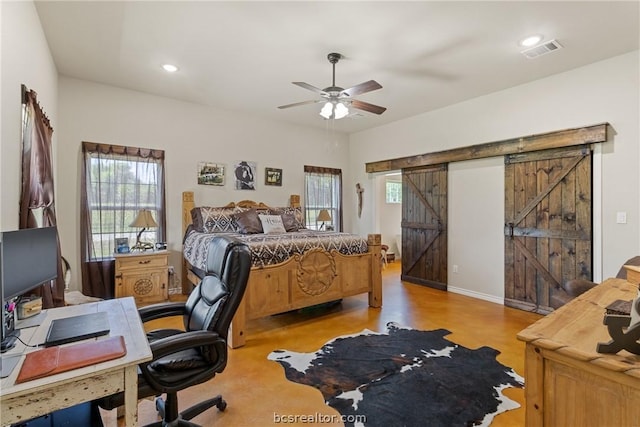 bedroom featuring ceiling fan, a barn door, and light hardwood / wood-style flooring