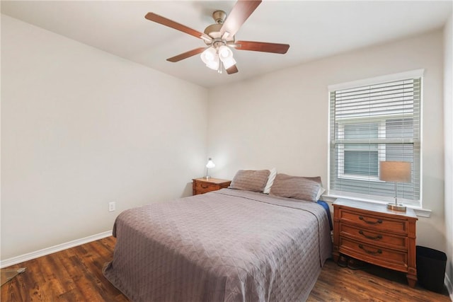 bedroom with a ceiling fan, baseboards, and dark wood-type flooring