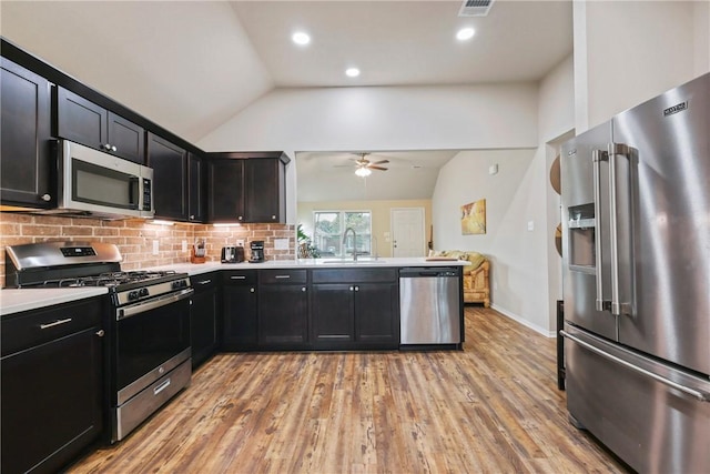 1208 High St, Navasota, TX 77868 - kitchen featuring lofted ceiling, a ceiling fan, dark cabinetry, a sink, and appliances with stainless steel finishes
