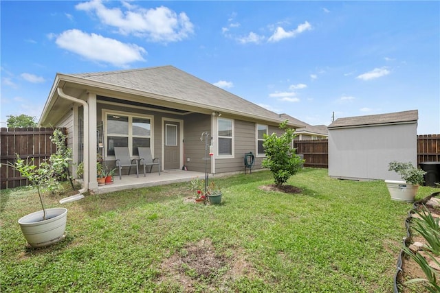 back of house featuring an outdoor structure, a fenced backyard, a patio area, a lawn, and a storage shed