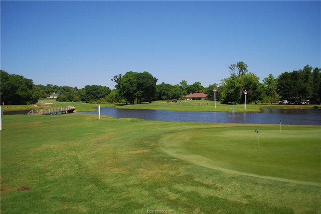 surrounding community featuring a lawn, view of golf course, and a water view