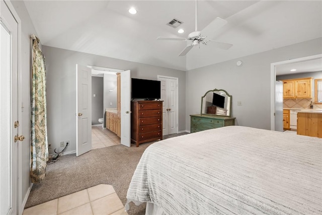 bedroom featuring ensuite bathroom, light colored carpet, baseboards, visible vents, and recessed lighting