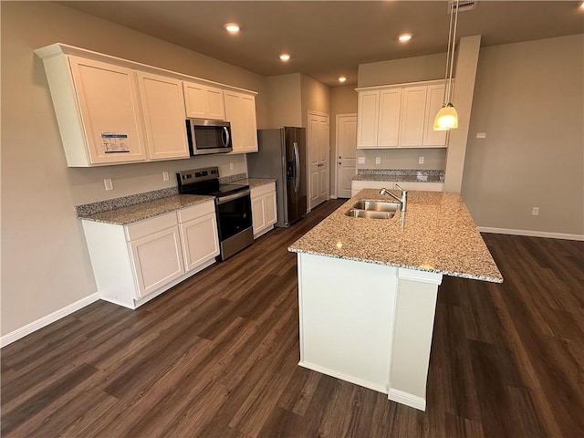 kitchen featuring pendant lighting, appliances with stainless steel finishes, sink, and white cabinets