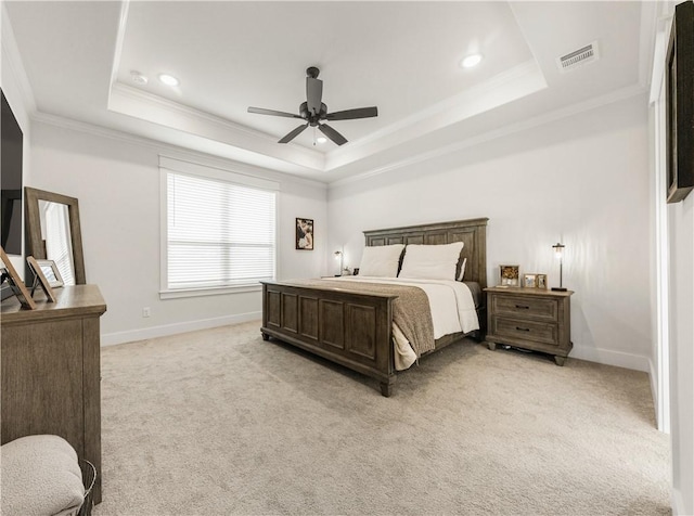 bedroom featuring visible vents, light carpet, a raised ceiling, ornamental molding, and baseboards