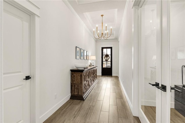 interior space featuring light wood finished floors, crown molding, and an inviting chandelier