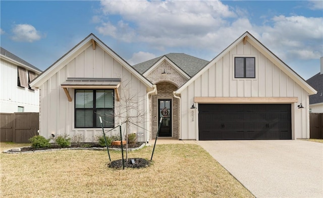 modern farmhouse style home with board and batten siding, a front lawn, fence, a garage, and driveway