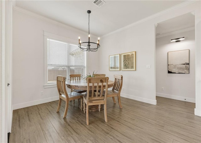 dining area with light wood-type flooring, visible vents, baseboards, and crown molding