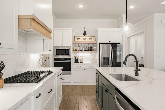 kitchen featuring a sink, stainless steel appliances, ornamental molding, and white cabinetry