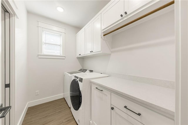 washroom featuring light wood-type flooring, recessed lighting, cabinet space, separate washer and dryer, and baseboards